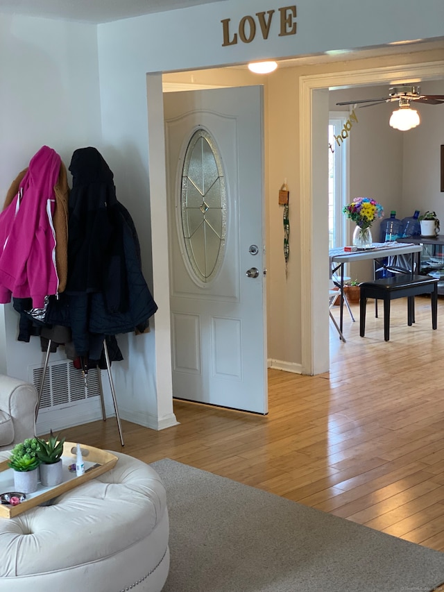 foyer with ceiling fan and light wood-type flooring