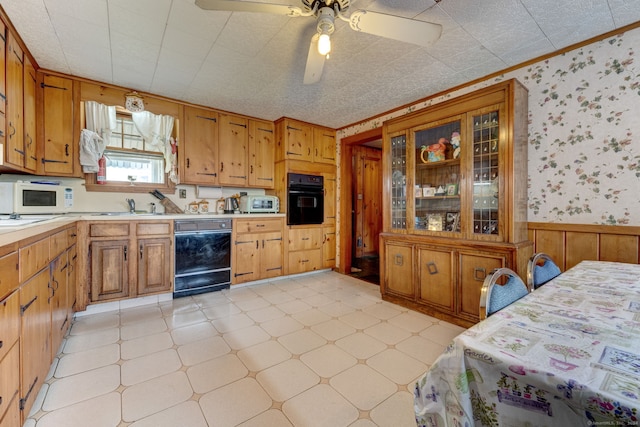 kitchen featuring ceiling fan, light tile floors, sink, crown molding, and black appliances