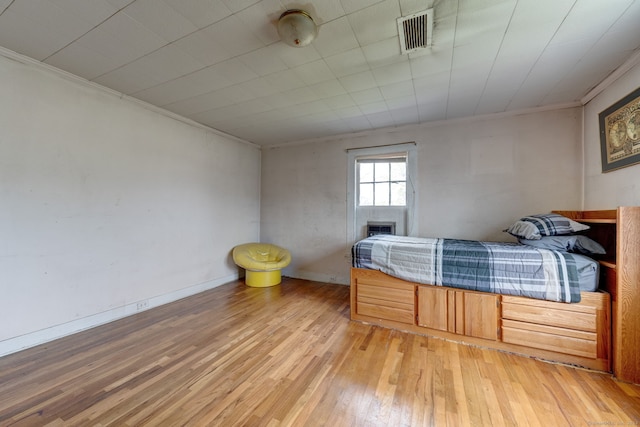 bedroom with hardwood / wood-style flooring and ornamental molding