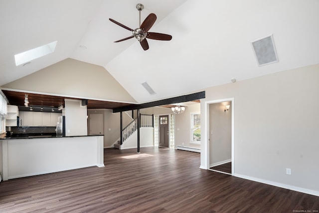 unfurnished living room featuring a skylight, dark wood-type flooring, high vaulted ceiling, a baseboard heating unit, and ceiling fan with notable chandelier