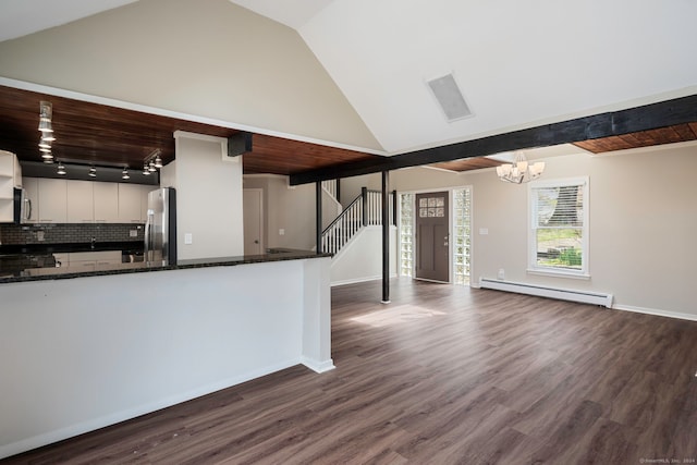 kitchen with white cabinetry, dark wood-type flooring, stainless steel appliances, baseboard heating, and vaulted ceiling