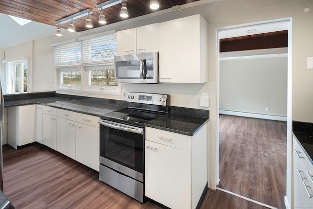 kitchen with baseboard heating, white cabinetry, stainless steel appliances, and dark hardwood / wood-style floors