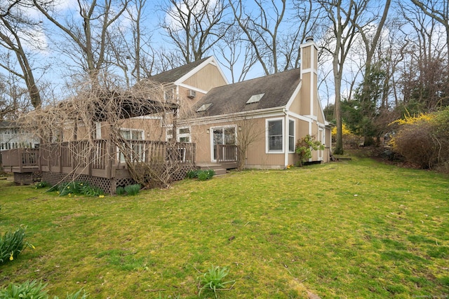 back of property with a lawn and a deck