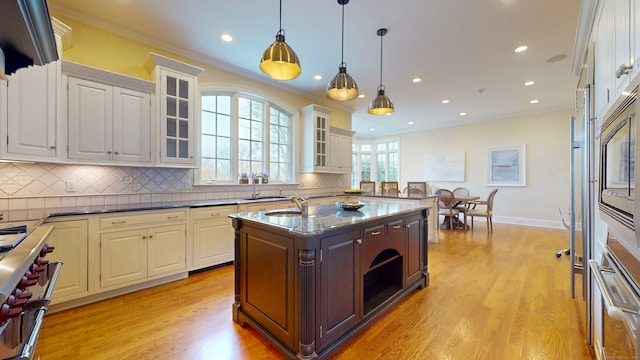 kitchen with backsplash, white cabinets, and light wood-type flooring