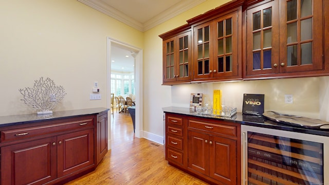 interior space featuring beverage cooler, crown molding, and light wood-type flooring