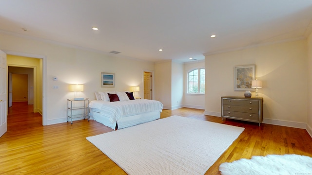 bedroom with crown molding and light hardwood / wood-style flooring