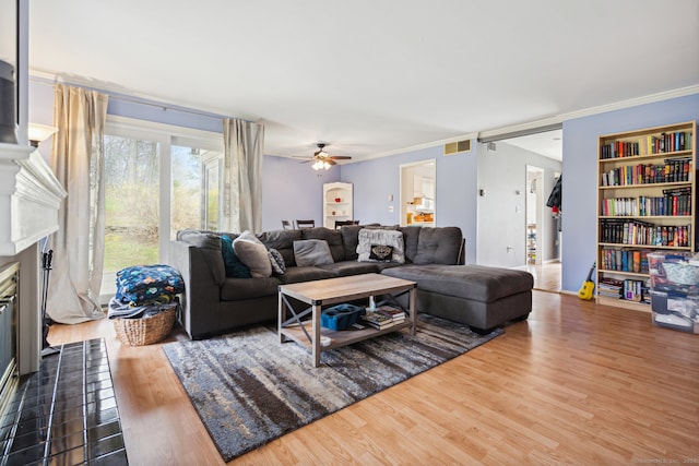 living room featuring hardwood / wood-style floors, ornamental molding, and ceiling fan