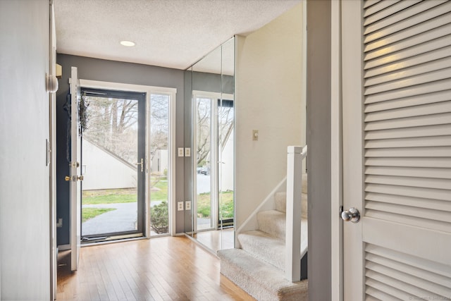 entrance foyer with light wood-type flooring and a textured ceiling