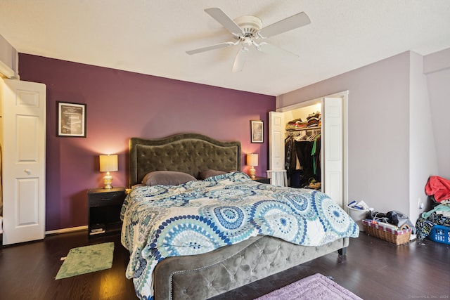 bedroom with a spacious closet, a closet, ceiling fan, and dark wood-type flooring