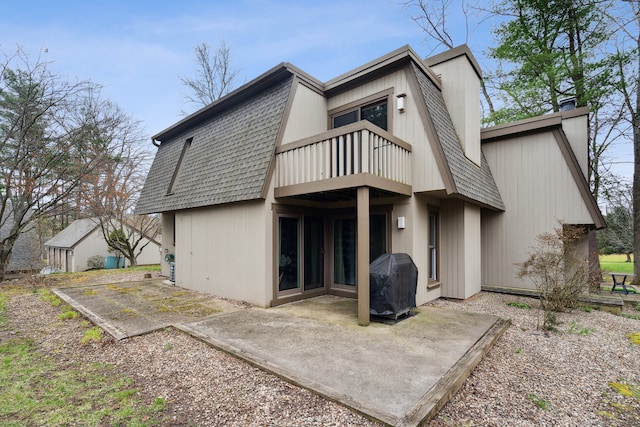 rear view of house featuring a patio area and a balcony