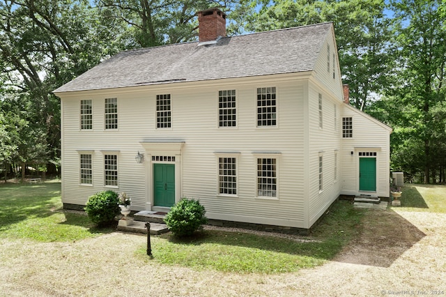 rear view of property with a lawn