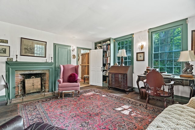 living room with a brick fireplace and dark hardwood / wood-style floors