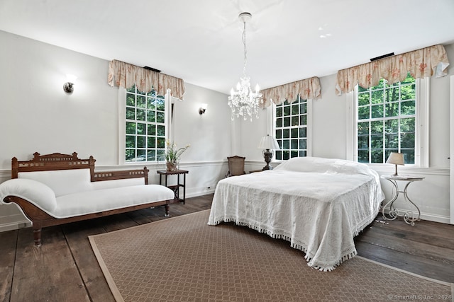 bedroom featuring dark wood-type flooring and an inviting chandelier