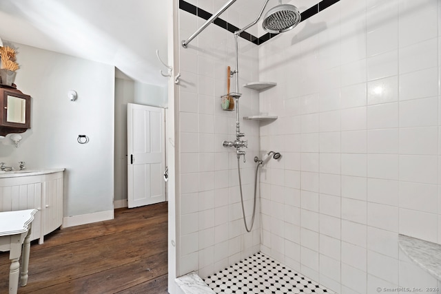 bathroom featuring sink, tiled shower, and hardwood / wood-style flooring