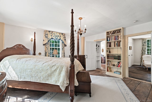 bedroom with a notable chandelier and dark hardwood / wood-style floors