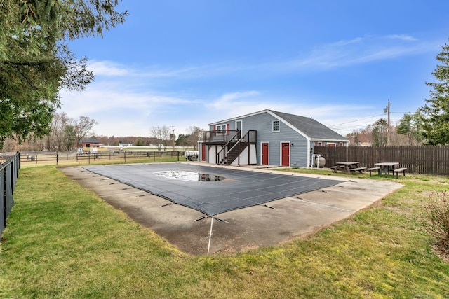 exterior space featuring a lawn and a covered pool