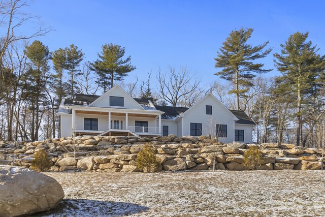 rear view of property featuring a porch