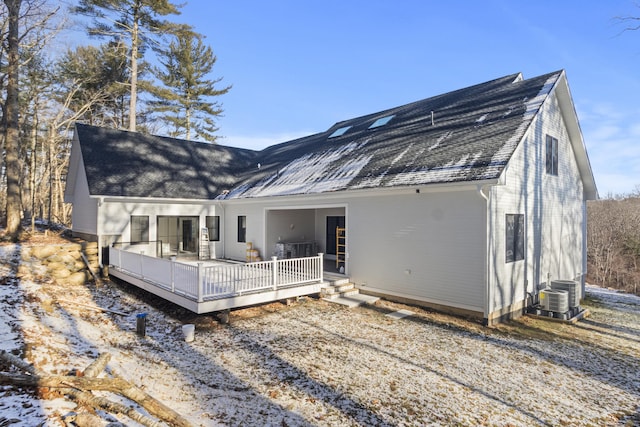 back of house featuring roof with shingles, a wooden deck, and central air condition unit