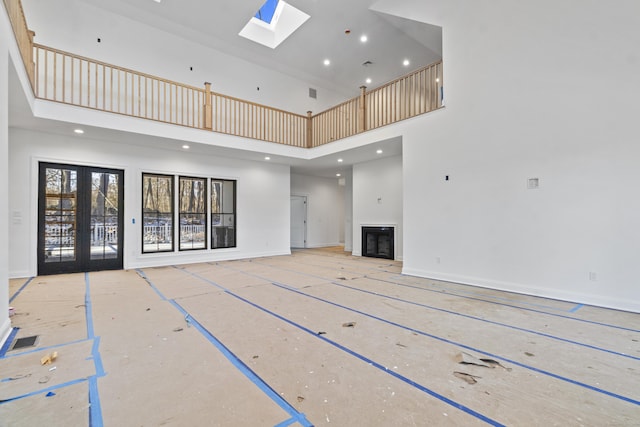 unfurnished living room with basketball court, a high ceiling, and french doors