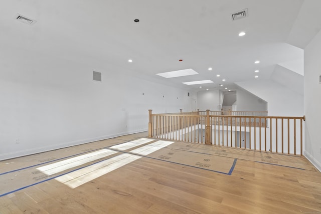 unfurnished room with light wood-type flooring, baseboards, visible vents, and recessed lighting