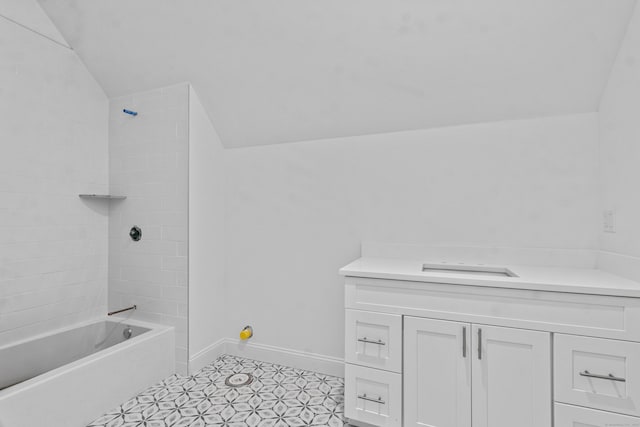 full bathroom featuring lofted ceiling, bathtub / shower combination, vanity, and baseboards