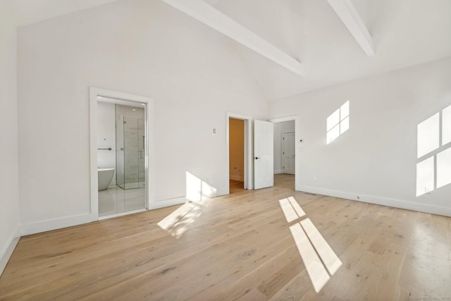 unfurnished bedroom featuring high vaulted ceiling, beam ceiling, connected bathroom, and light hardwood / wood-style flooring