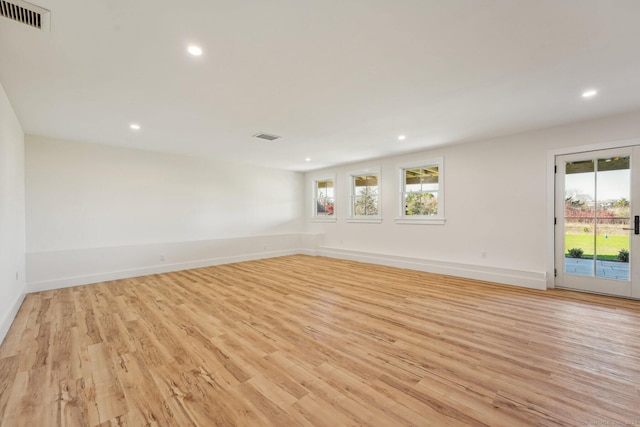 spare room with a wealth of natural light and light hardwood / wood-style flooring