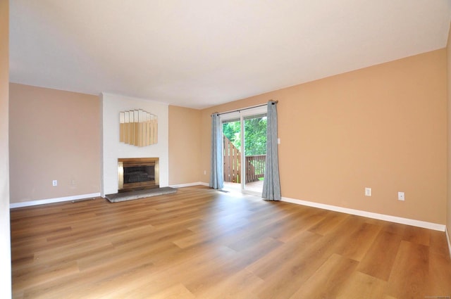 29 Early Dawn Cir Unit 29, Windsor, CT 06095 - unfurnished living room with light wood finished floors and a glass covered fireplace