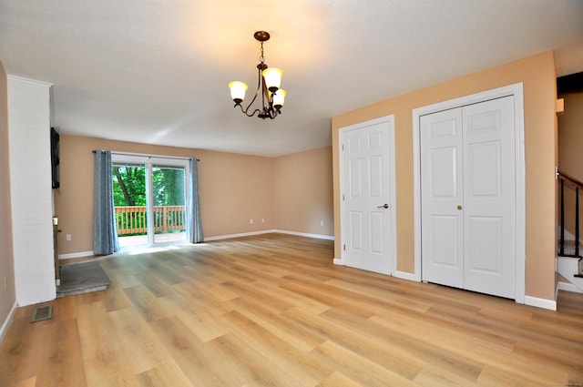 29 Early Dawn Cir Unit 29, Windsor, CT 06095 - unfurnished living room featuring a chandelier and light wood-style flooring