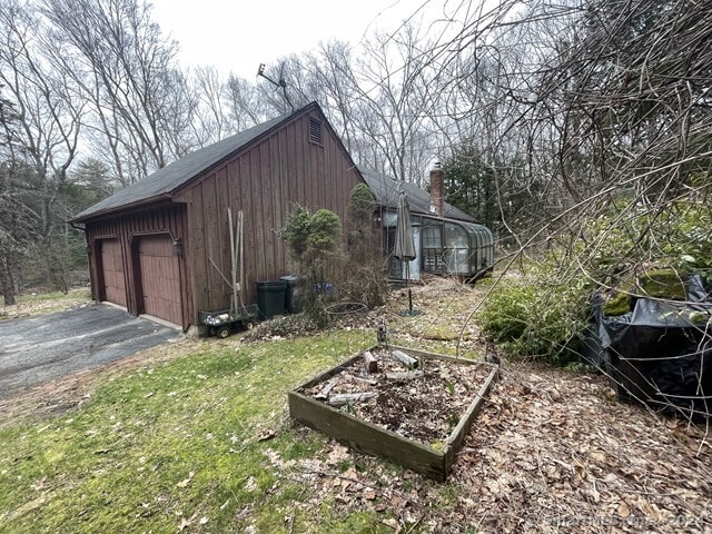 view of side of property featuring an outdoor structure and a garage