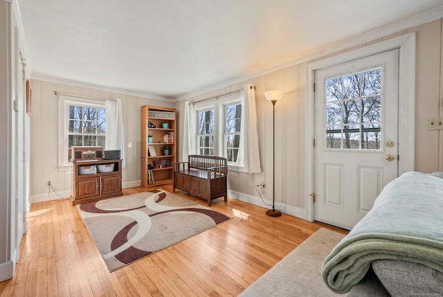 bedroom featuring crown molding, light hardwood / wood-style floors, and multiple windows