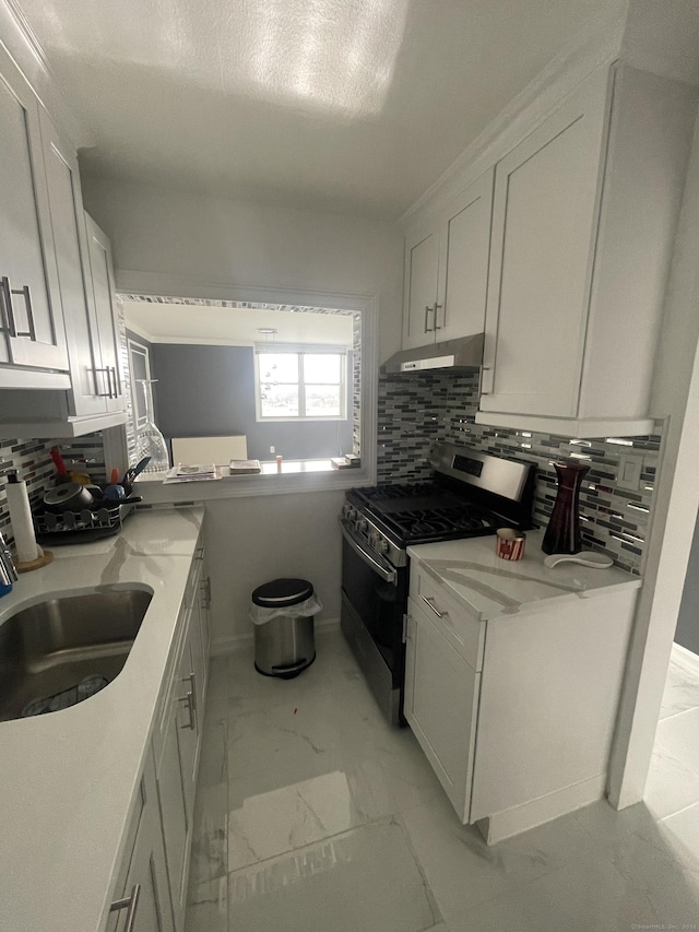 kitchen featuring white cabinets, backsplash, sink, and stainless steel range with gas stovetop