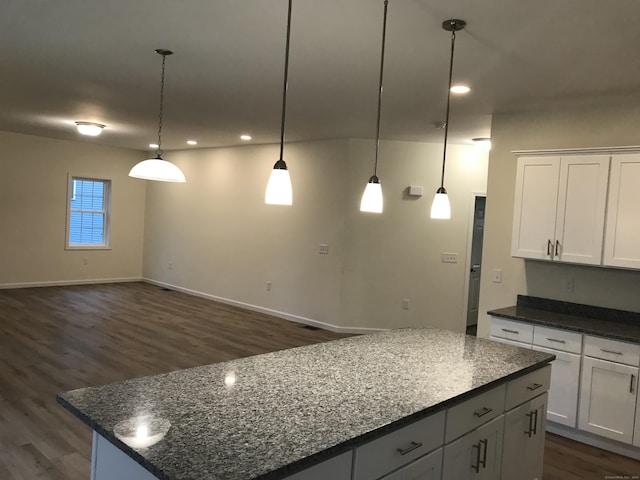 kitchen with white cabinets, decorative light fixtures, and a kitchen island