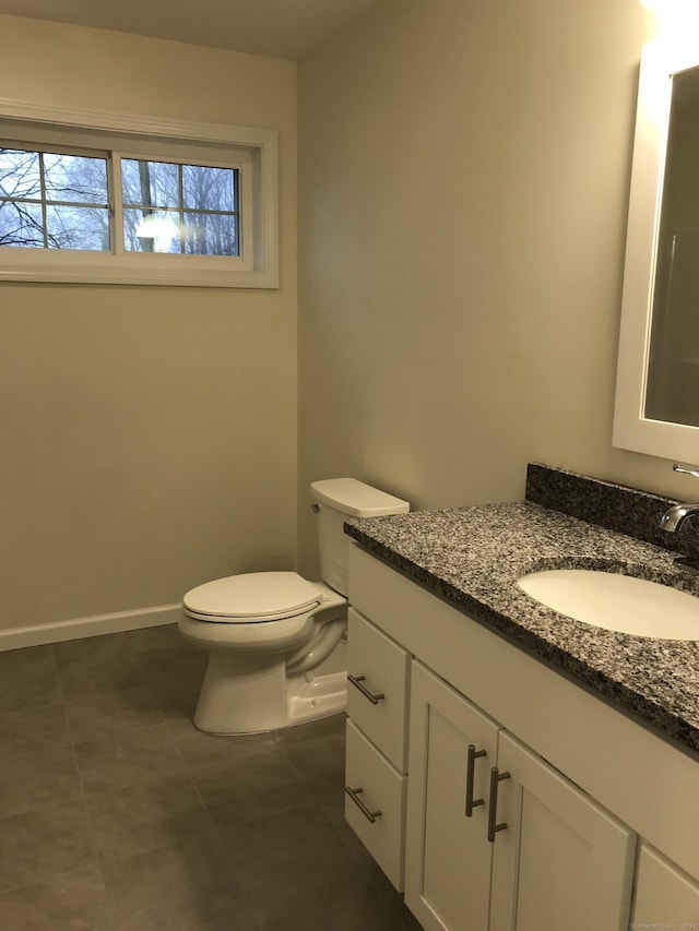 bathroom with tile patterned flooring, vanity, and toilet