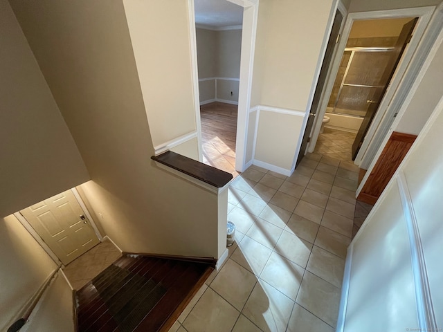 corridor with ornamental molding and light tile patterned floors