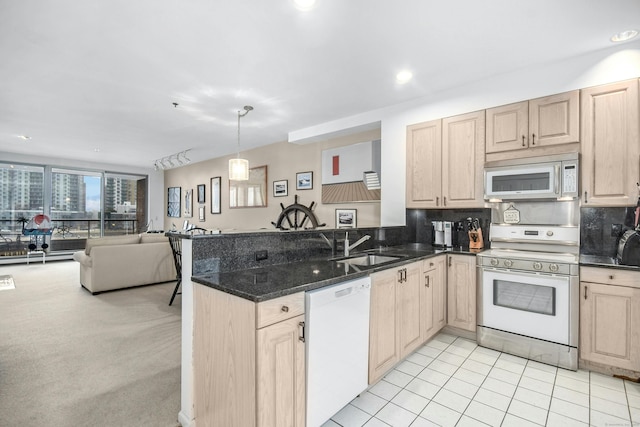 kitchen featuring pendant lighting, white appliances, light brown cabinets, kitchen peninsula, and light colored carpet