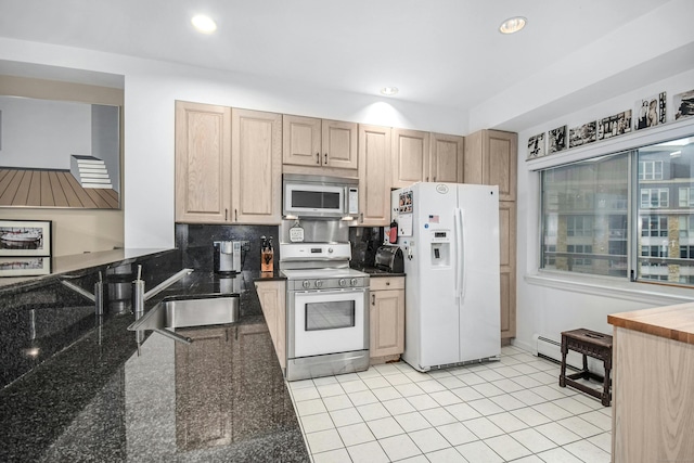 kitchen featuring sink, white appliances, light tile flooring, backsplash, and dark stone counters