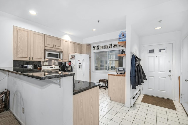 kitchen featuring white refrigerator with ice dispenser, a baseboard radiator, light tile flooring, kitchen peninsula, and dark stone countertops