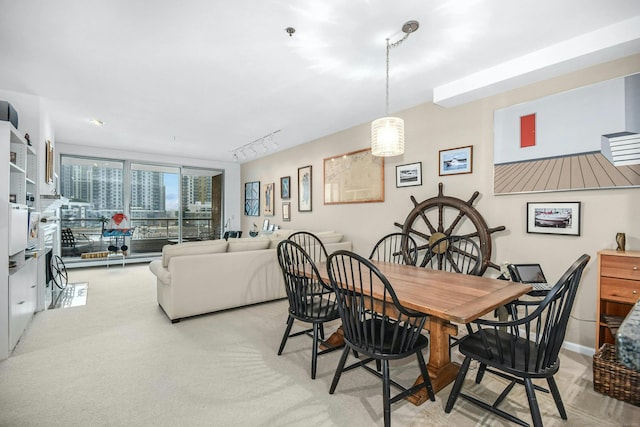 carpeted dining room with track lighting