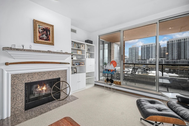 carpeted living room featuring a high end fireplace