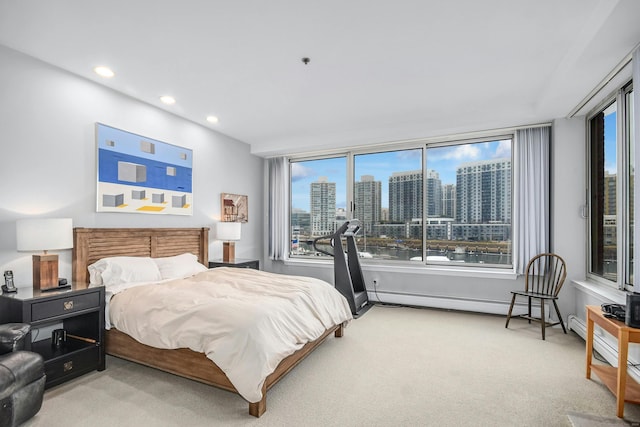 bedroom with light carpet and a baseboard radiator