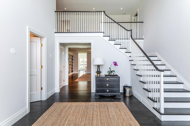 stairs with a high ceiling and hardwood / wood-style floors