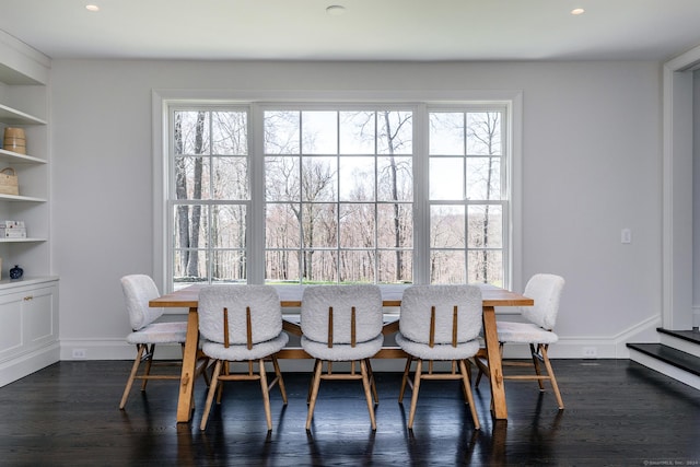 dining room with dark hardwood / wood-style flooring, a wealth of natural light, and built in features