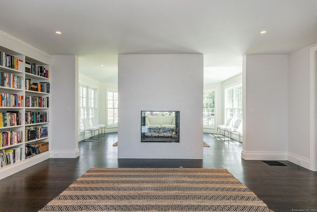 corridor with dark hardwood / wood-style floors and built in features