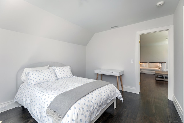 bedroom featuring lofted ceiling and dark hardwood / wood-style flooring