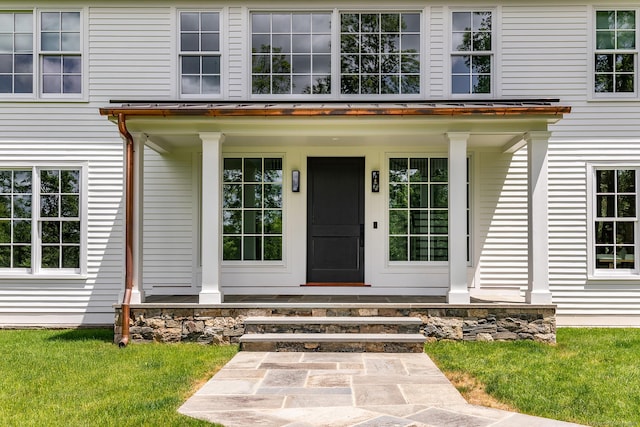 property entrance featuring a lawn