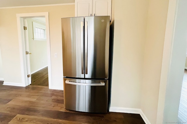 kitchen with hardwood / wood-style flooring, stainless steel refrigerator, white cabinetry, and crown molding