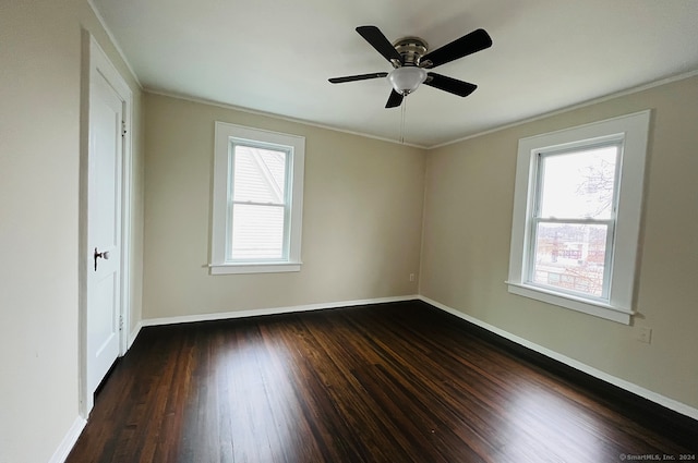 empty room featuring ornamental molding, ceiling fan, and dark wood-type flooring