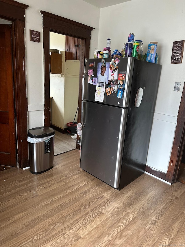 kitchen featuring stainless steel fridge and light hardwood / wood-style flooring