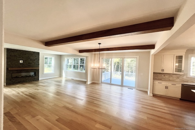 unfurnished living room featuring an inviting chandelier, light wood-type flooring, beam ceiling, and a fireplace